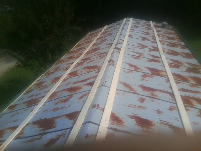 Rusted metal roof panels with new wood purlins before replacement — Storm Damage Roof Repair in Euclid by Roofing Brothers