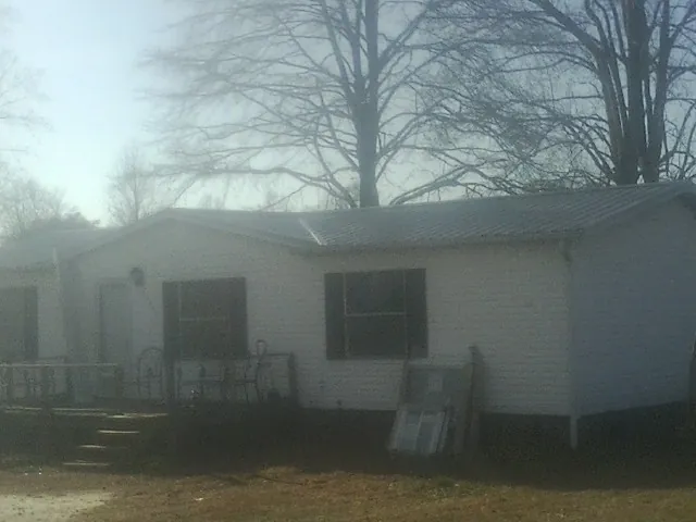 New metal roof on a white painted brick home on a foggy morning in Euclid