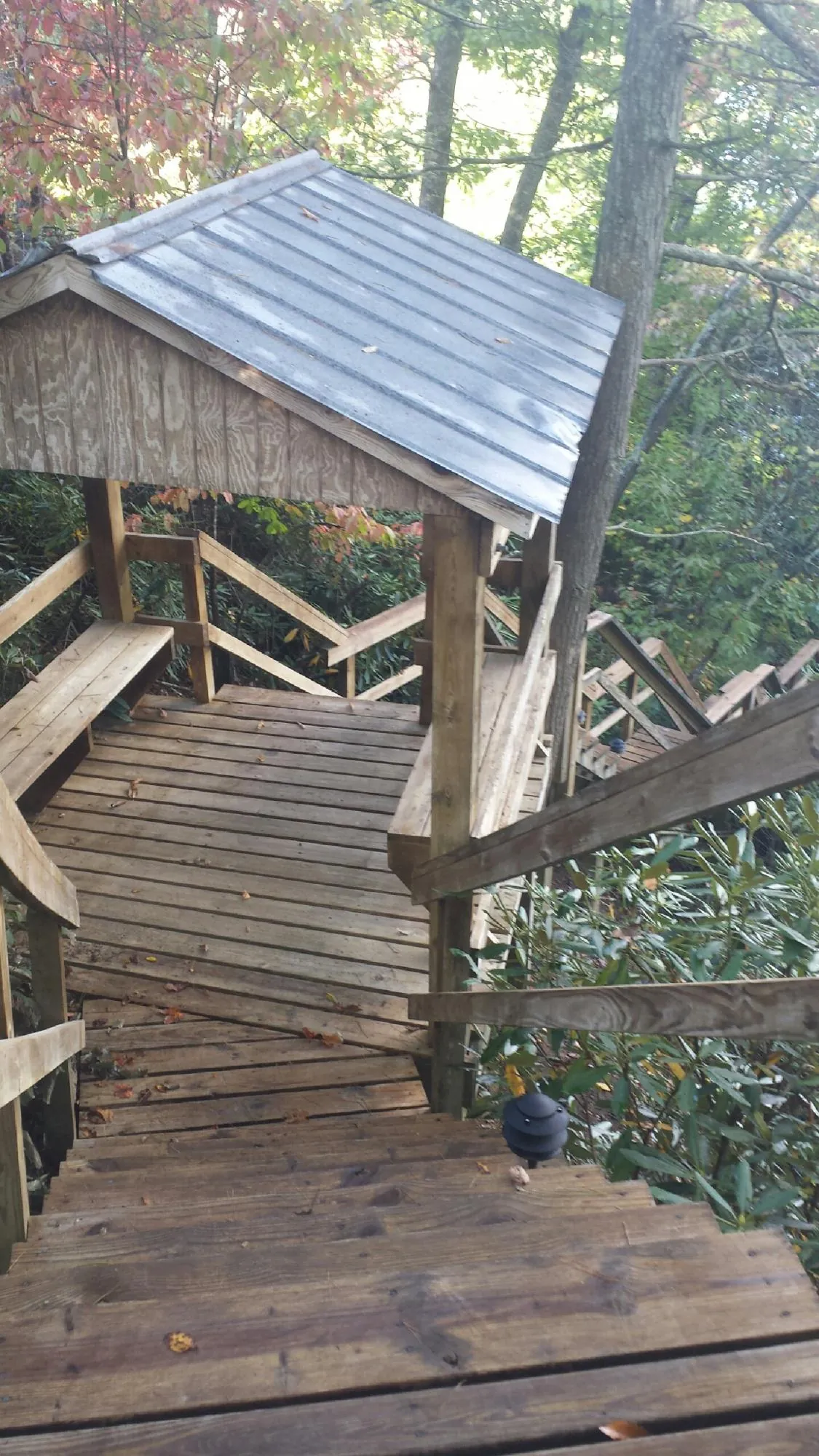Metal roofed shelter over wooden steps on a wooded walkway — Skylight Repair & Installation work by our crew in Euclid