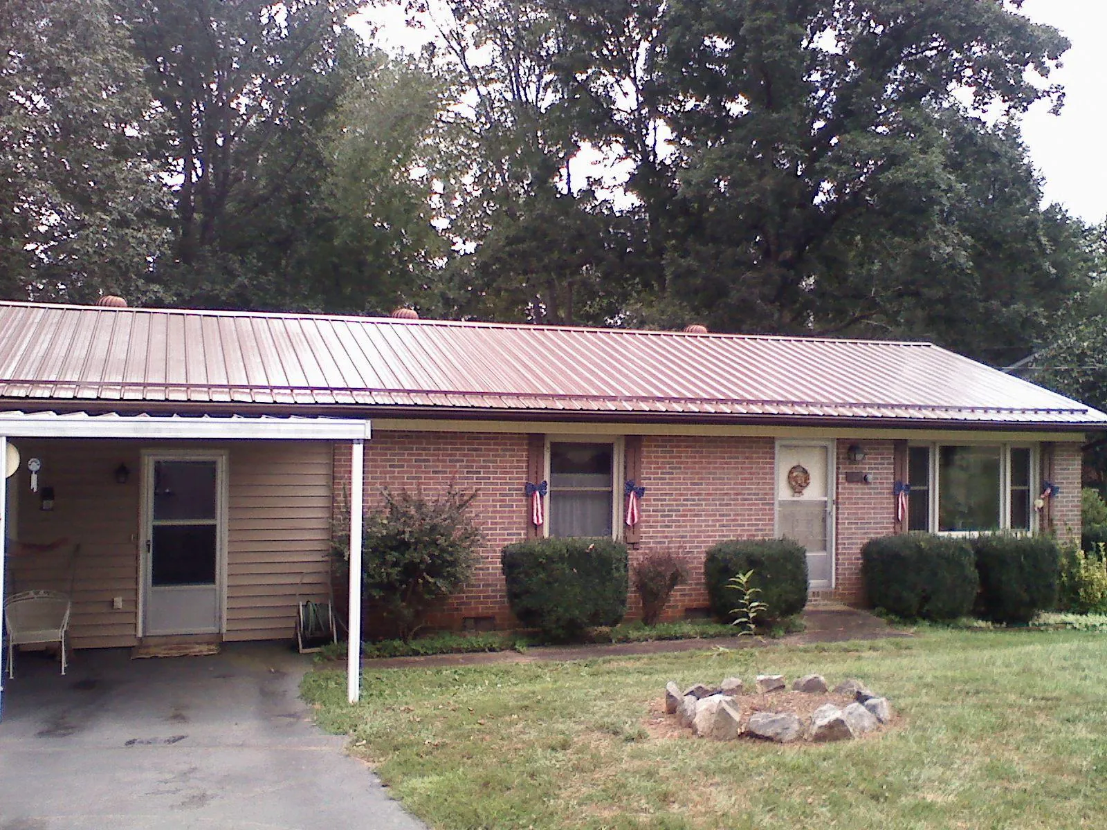 Bronze metal roof and carport on a brick ranch home — Roof Repair work by our crew in Euclid
